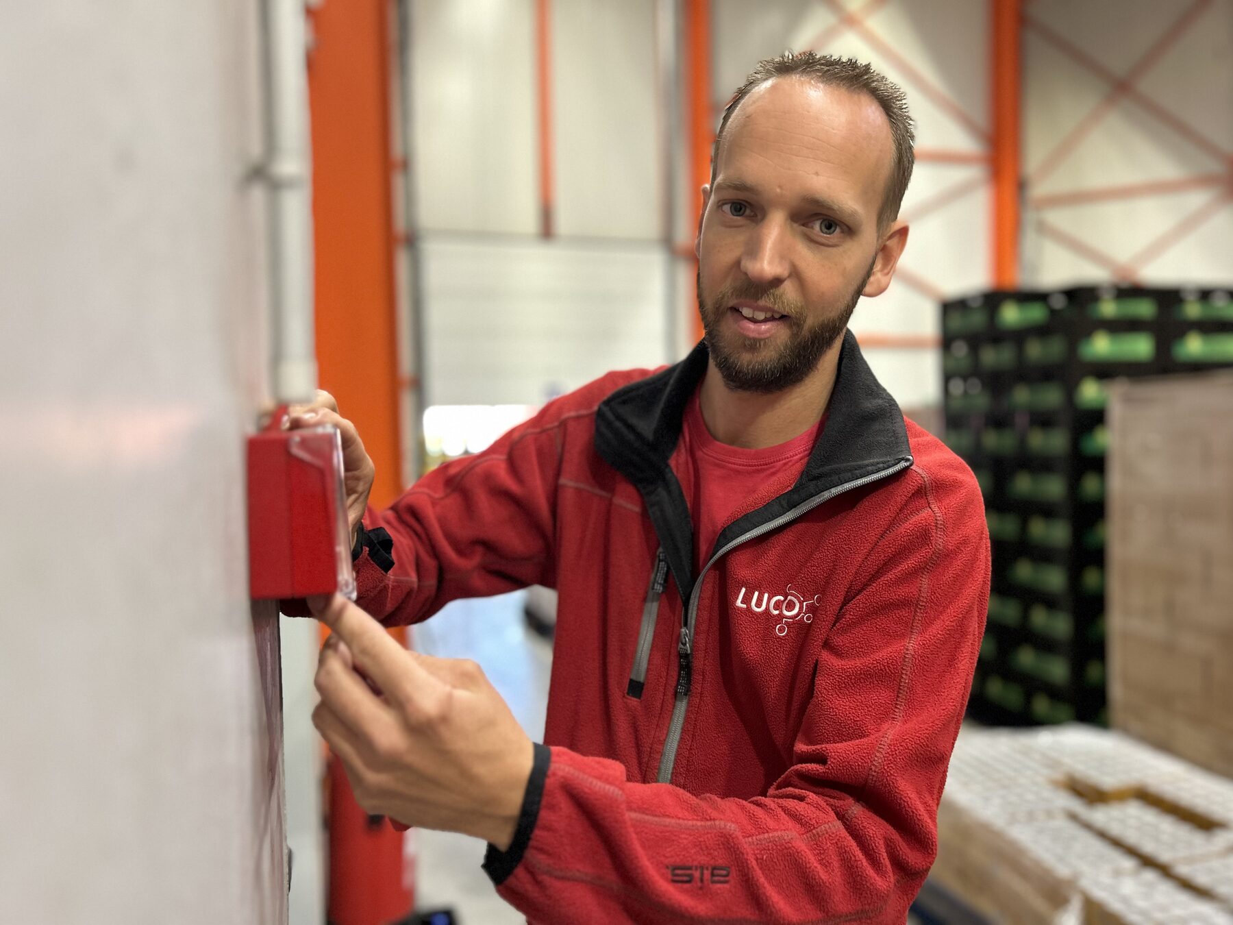 LUCO-technieker plaatst een handbrandmelder in een bedrijfsgebouw