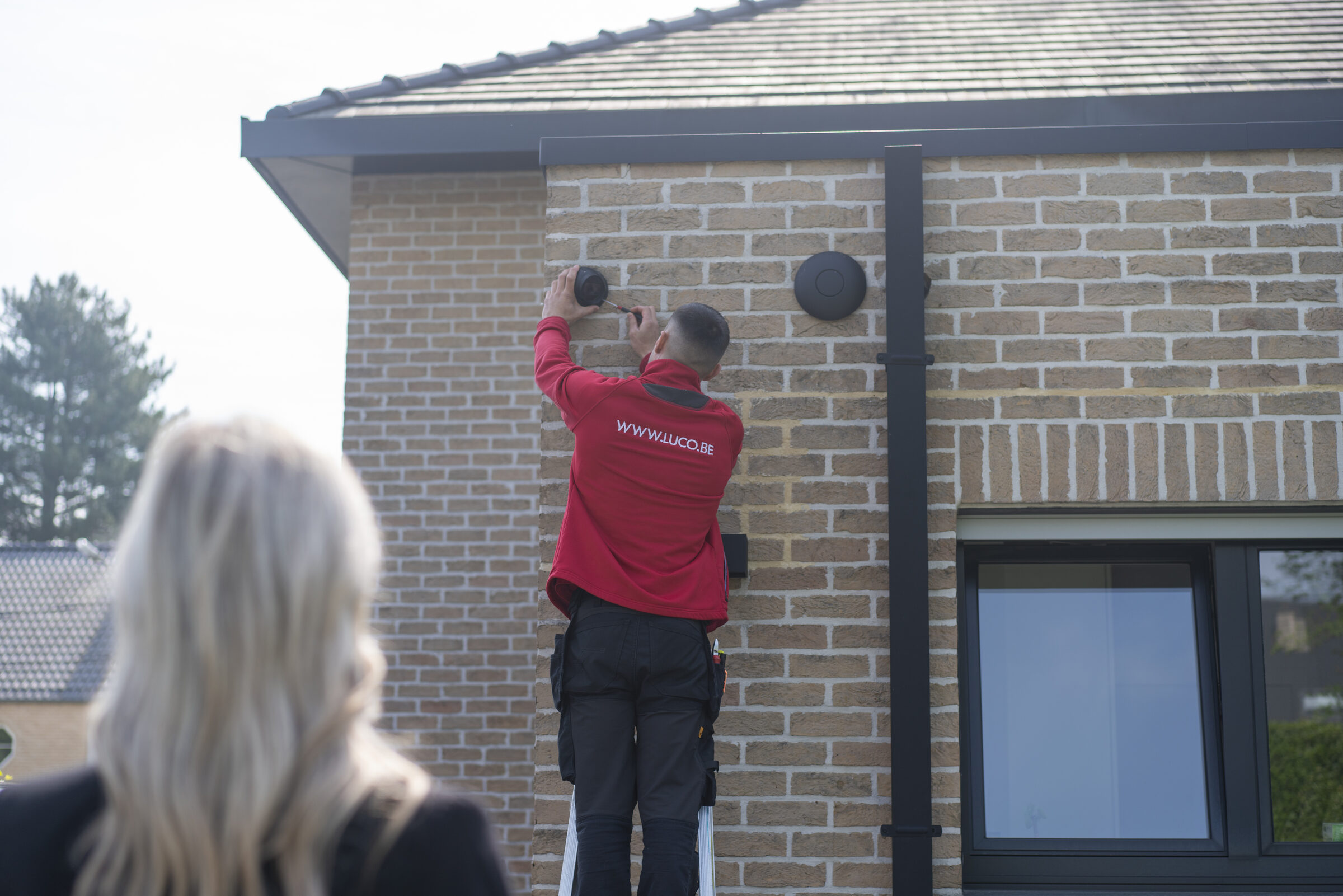 LUCO-technieker plaatst beveiliging aan een woning terwijl de klant meekijkt